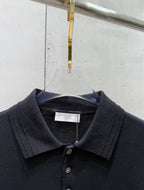 Black polo shirt neckline with button placket and white brand tag
