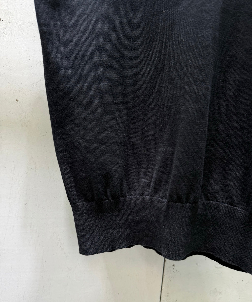 Black polo shirt hem with ribbed cuffs and gathered bottom