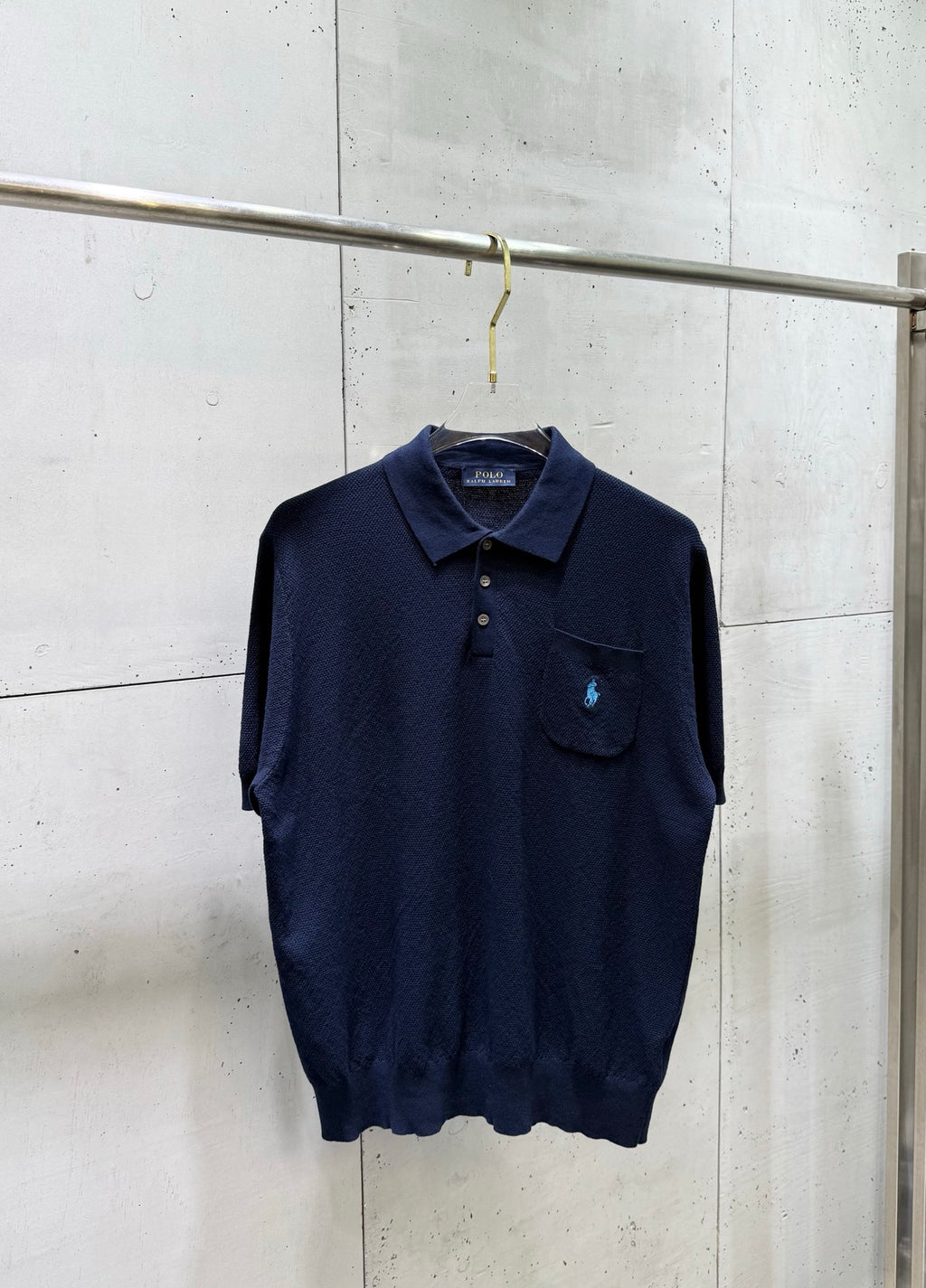 Navy knit polo sweater with button placket and chest pocket