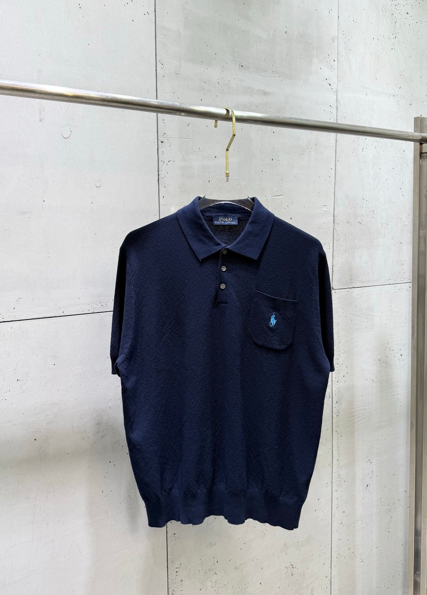 Navy knit polo sweater with button placket and chest pocket