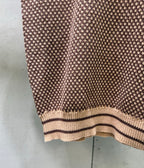 Knit polo shirt hem with striped rib trim, textured pattern knit close-up