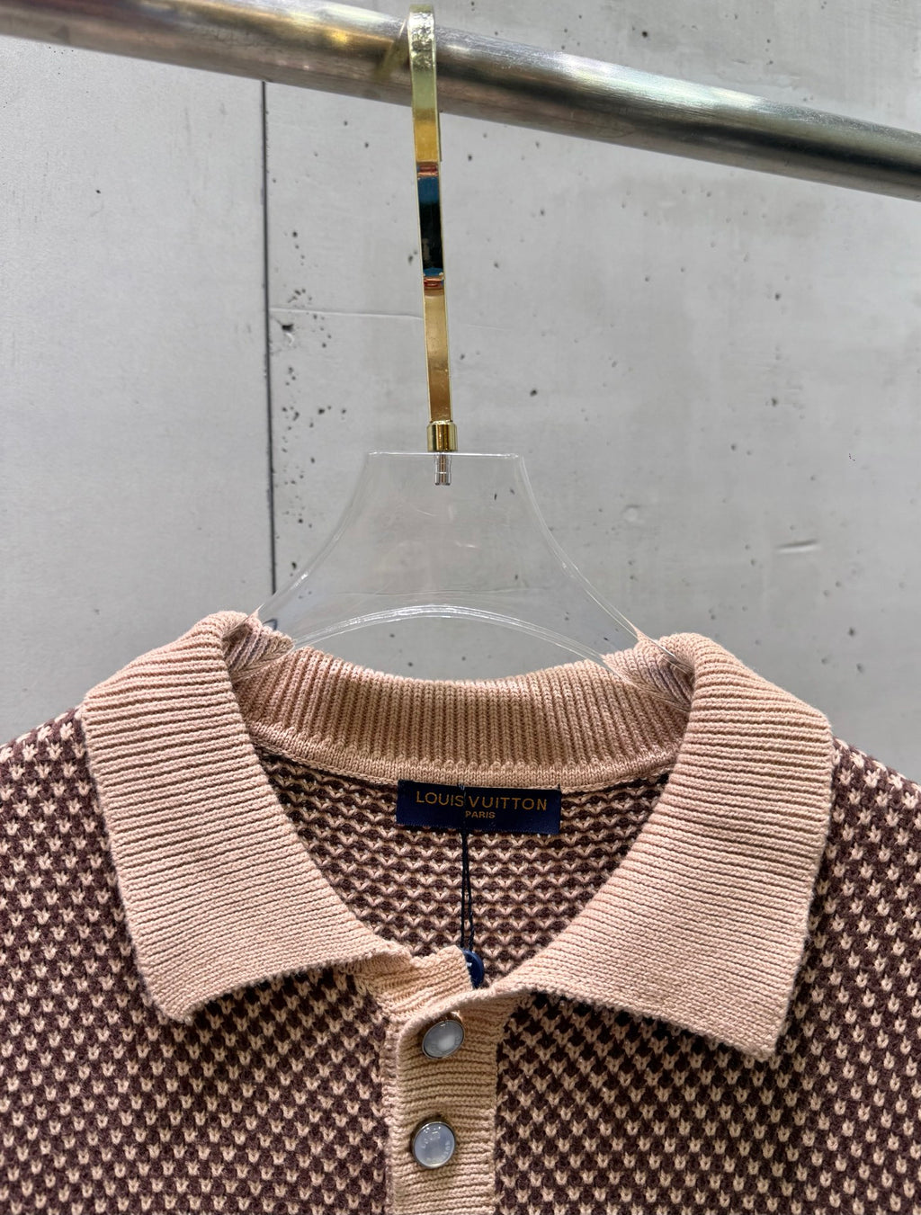 Knit polo shirt neckline detail with ribbed collar, three-button placket, brand label