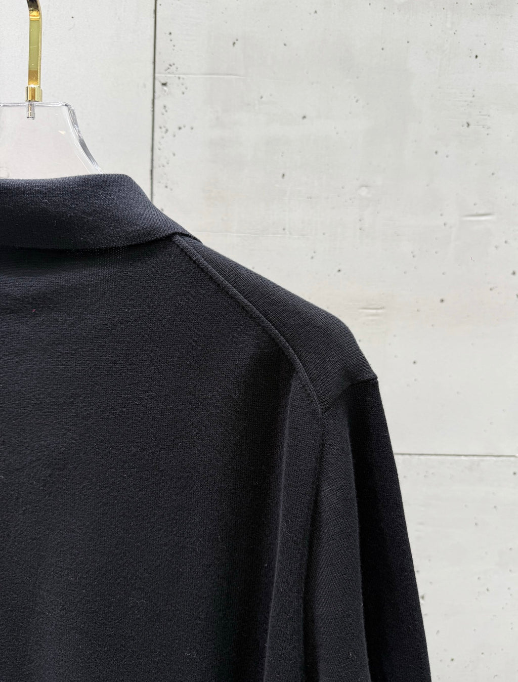 Black polo shirt side view with shoulder seam and sleeve cuff
