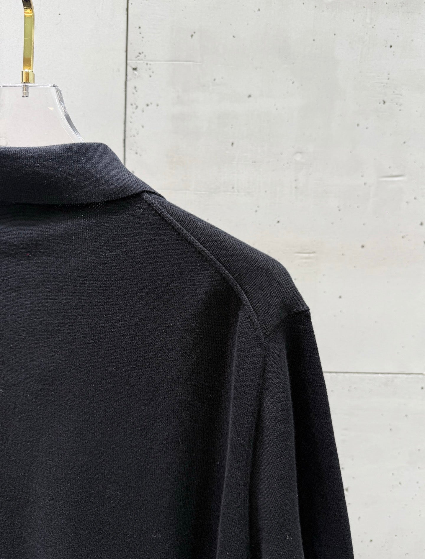 Black polo shirt side view with shoulder seam and sleeve cuff