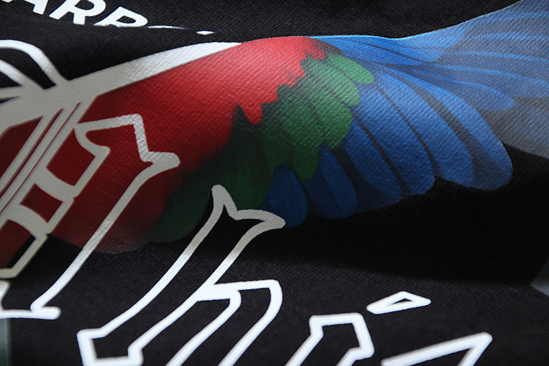 Black T-shirt front graphic with red, green, and blue bird wings