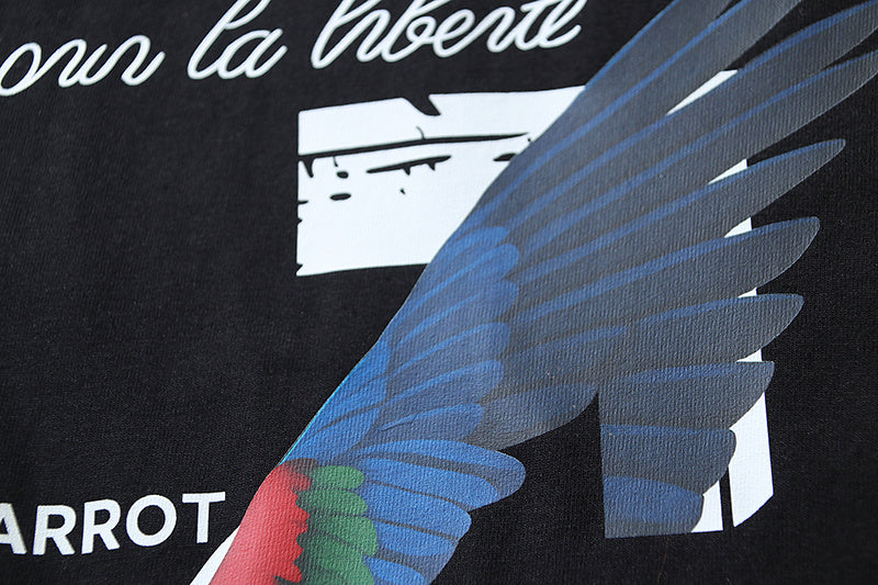 Black T-shirt close-up with blue bird wing graphic and text accents