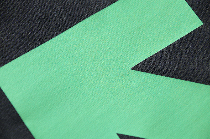 Green arrow X graphic on dark T-shirt front