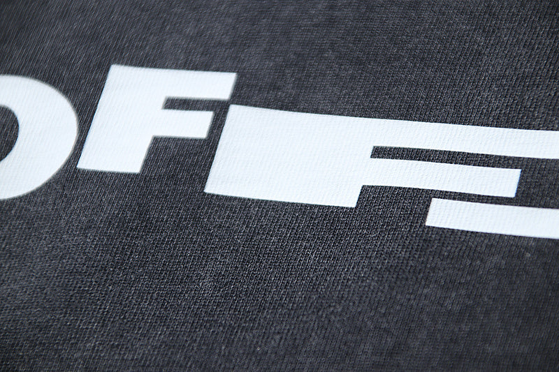 White graphic lettering on dark gray T-shirt fabric close-up