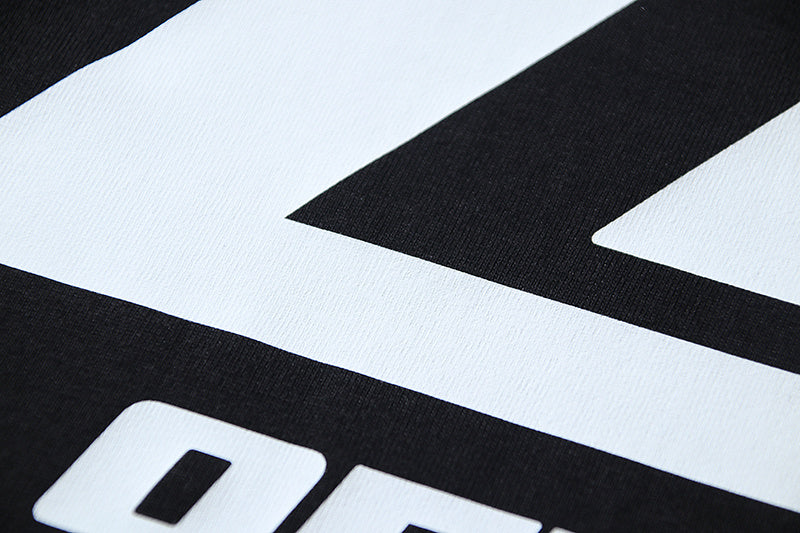 Close-up of white Off-White logo text on black T-shirt