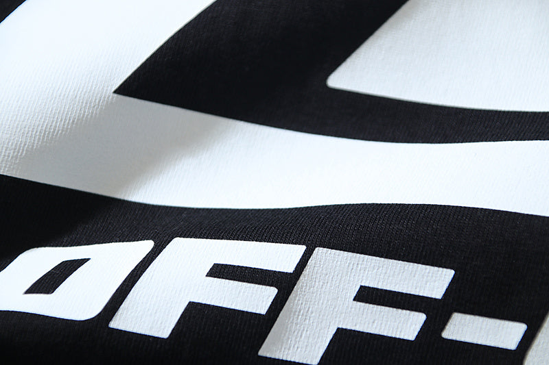 Close-up of large white logo letters on black graphic T-shirt