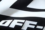 Close-up of large white logo letters on black graphic T-shirt