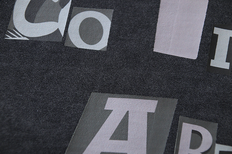 Large white and gray graphic letters on black T-shirt