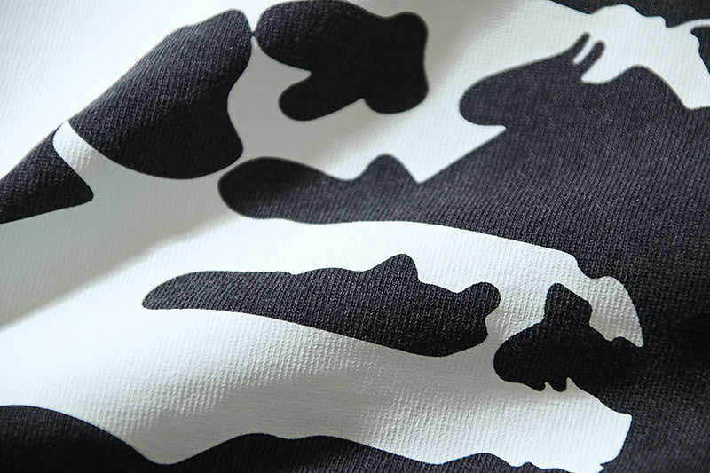 Abstract white-and-black graphic print on dark T-shirt fabric, folded