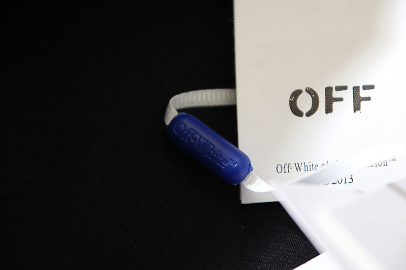Off-White clothing label with blue zip tie on white tag
