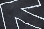 Black T-shirt graphic corner with white printed lines and arrows