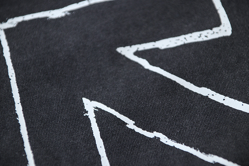 Black T-shirt graphic corner with white printed lines and arrows