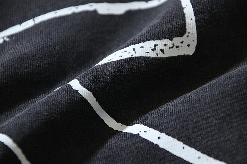Black T-shirt graphic close-up with white paint-like lines