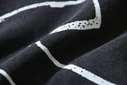 Black T-shirt graphic close-up with white paint-like lines