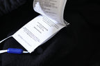 Off White hang tag on dark garment with printed care text and blue clip