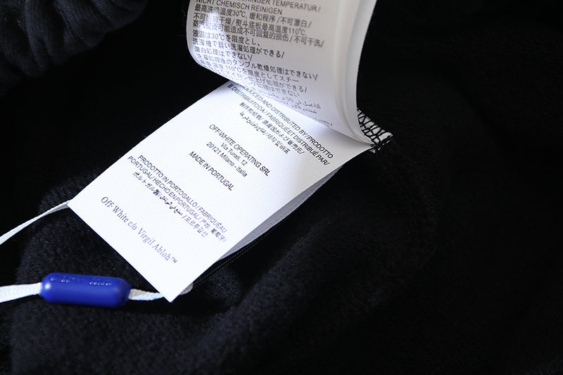 Off White hang tag on dark garment with printed care text and blue clip