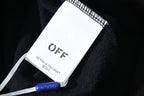 Off White clothing label on dark fabric, with blue plastic tag fastener