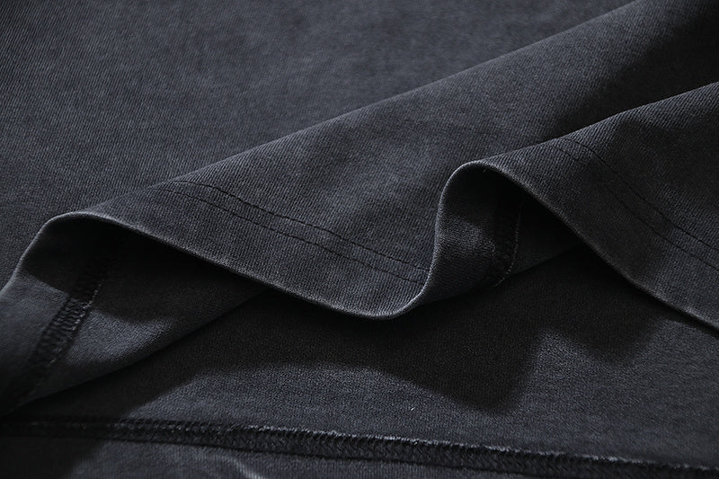 Dark T-shirt fabric close-up with stitched seam detail