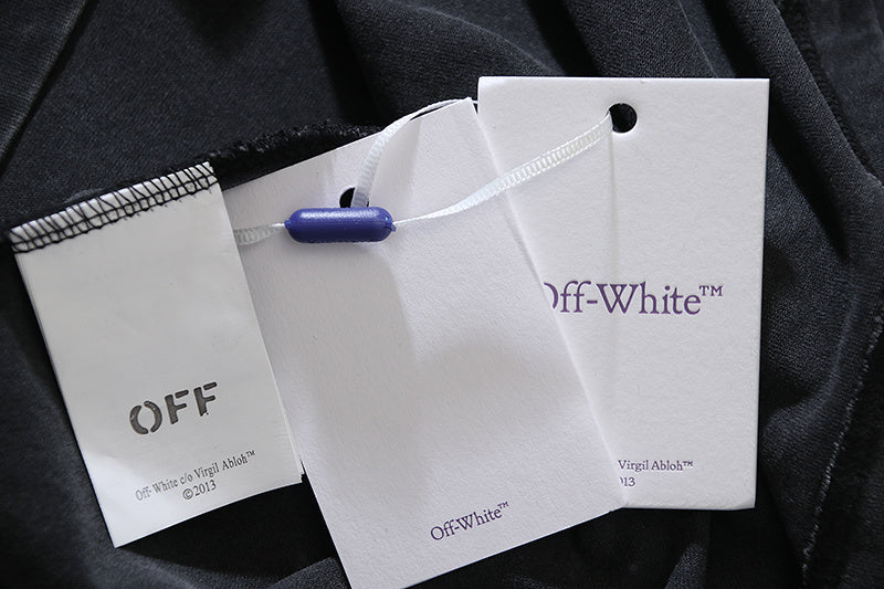 Off-White clothing tags attached to black T-shirt fabric