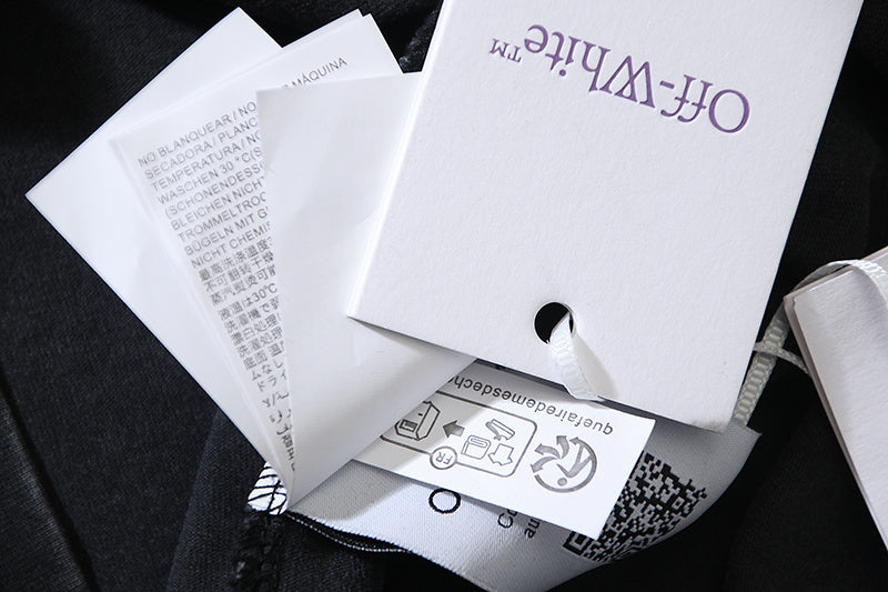 Clothing hang tags with hole punch, white paper on dark fabric