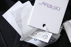 Clothing hang tags with hole punch, white paper on dark fabric