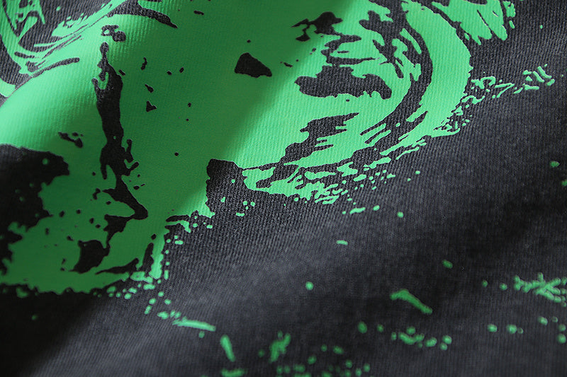 Black T-shirt fabric with green splash print and dotted speckle detail