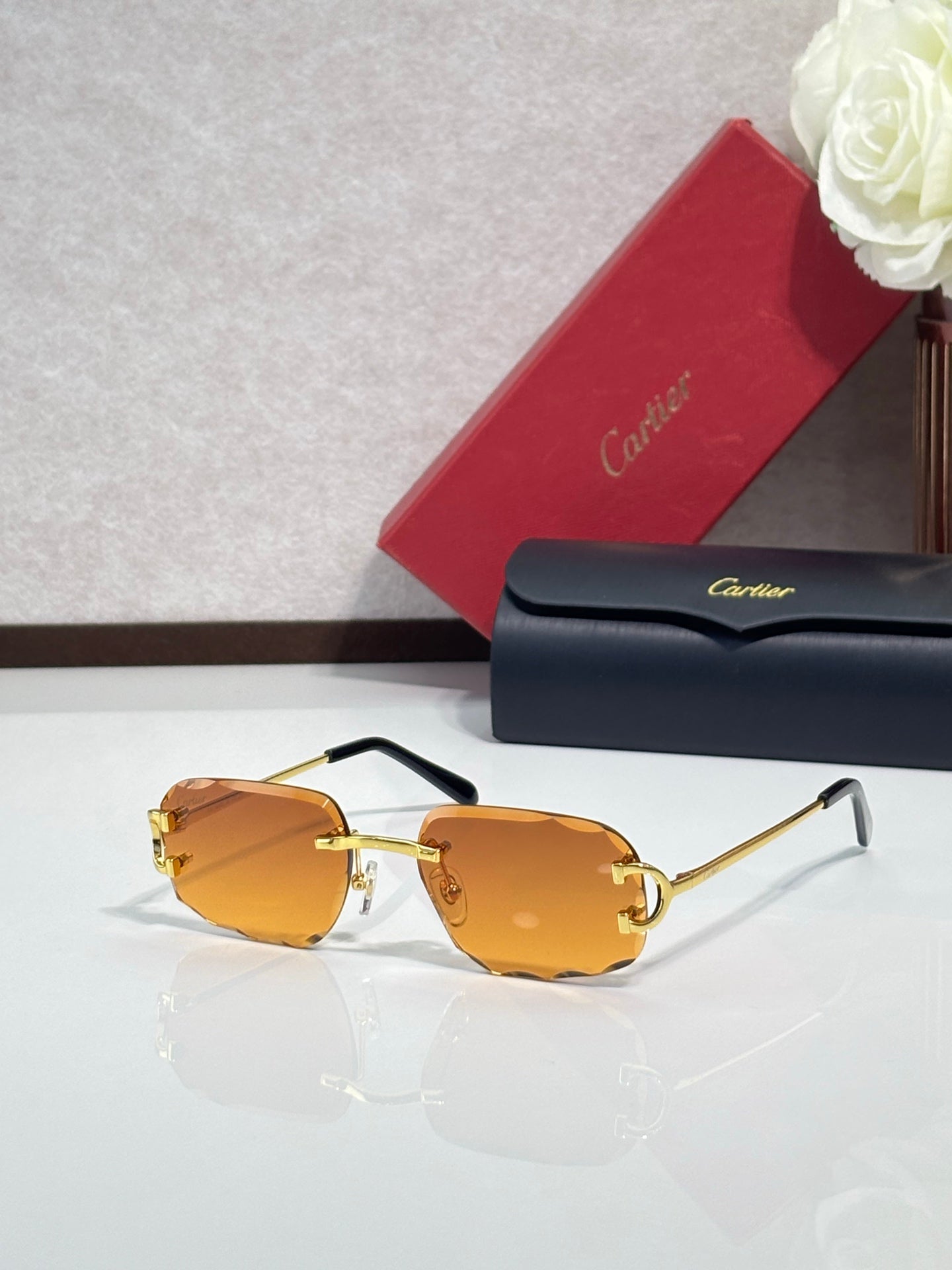 Cartier eyeglasses with amber-orange lenses, gold frame, black arms