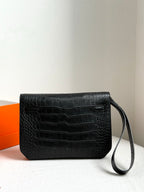 Hermes bag with dark croc-embossed finish, front flap, and attached wrist strap