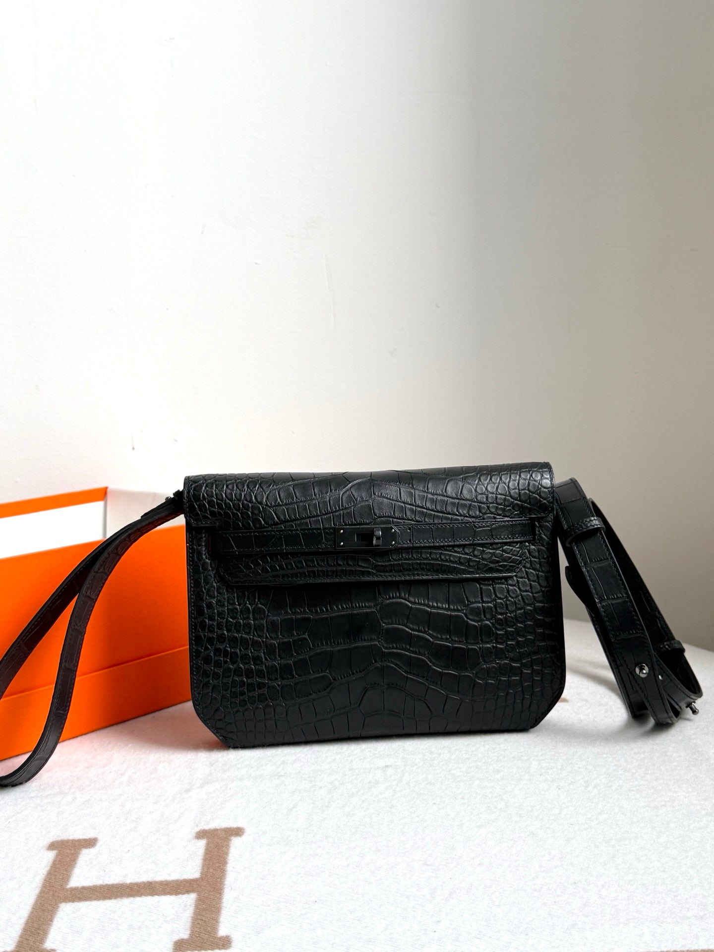 Hermes bag in dark crocodile-embossed leather with front flap and wrist strap