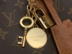Gold key and padlock charms on Louis Vuitton monogram bag hardware
