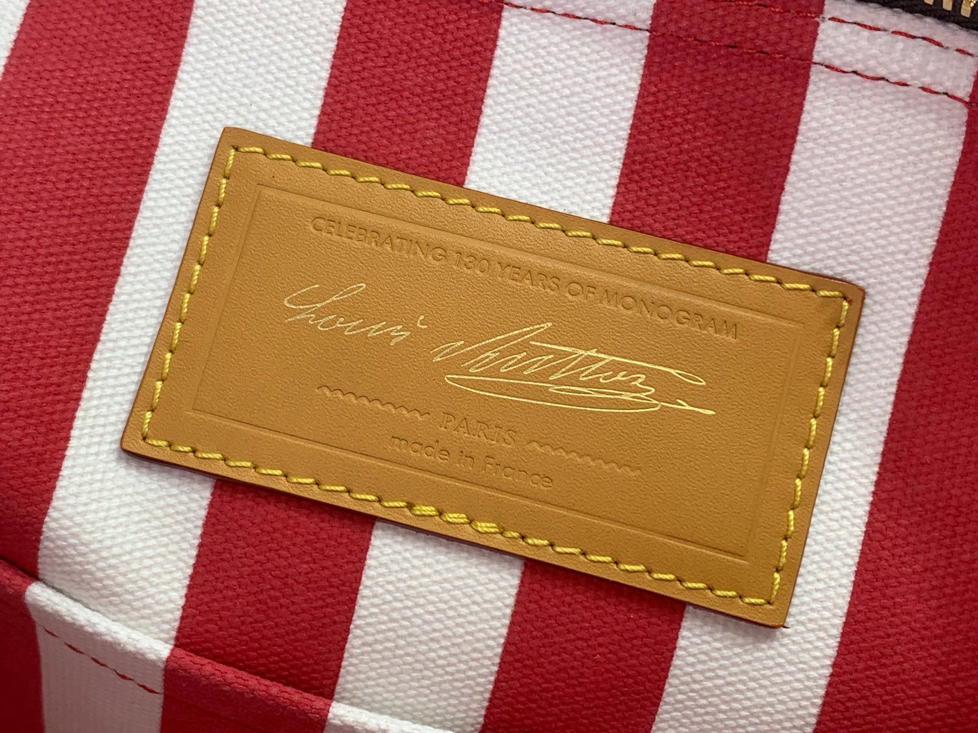 Leather brand patch on red-and-white striped tag on monogram bag