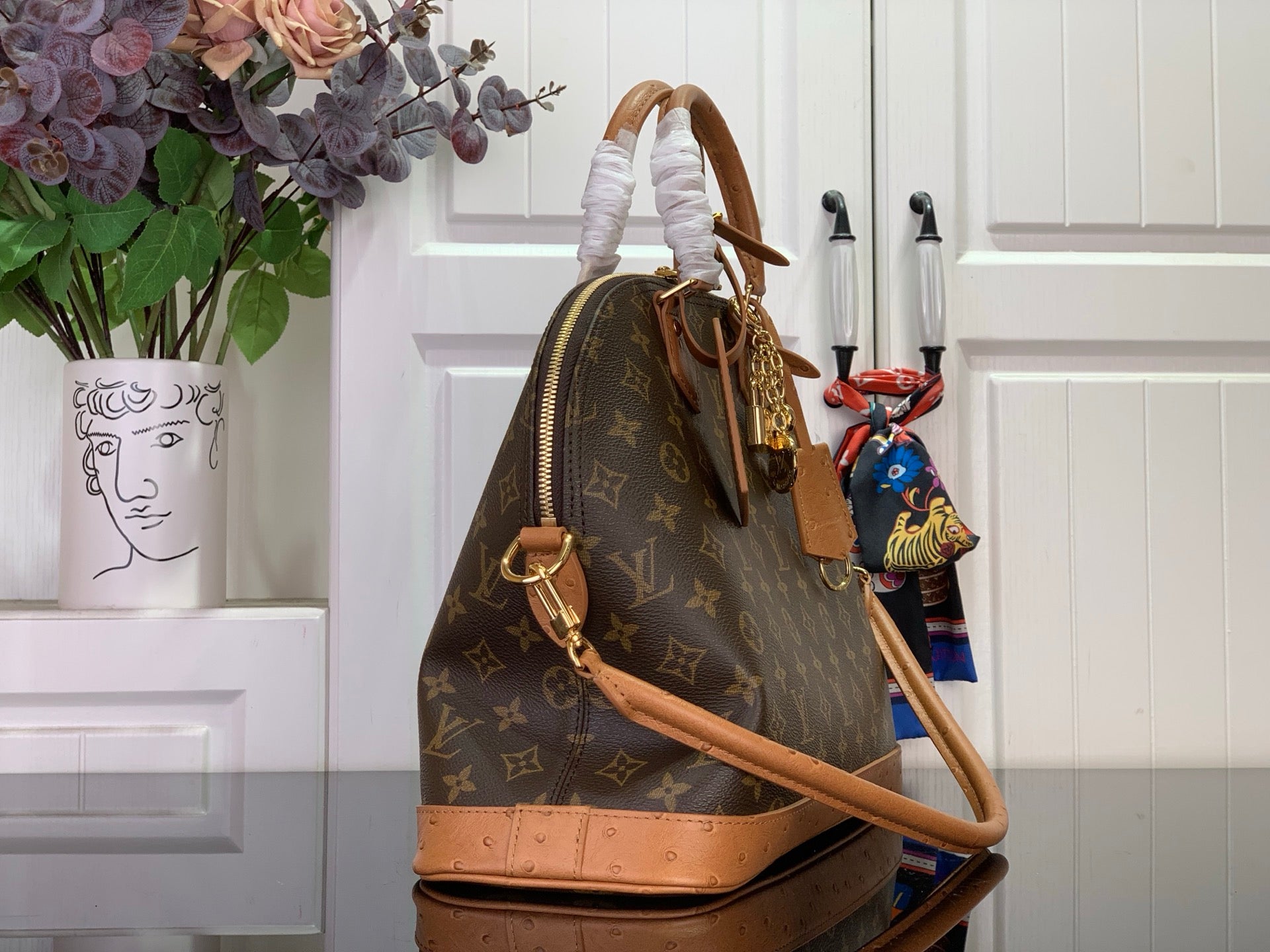 Louis Vuitton monogram duffel bag with tan leather strap and hanging charm
