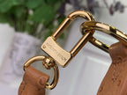 Gold clasp hardware with engraved charm on tan leather strap