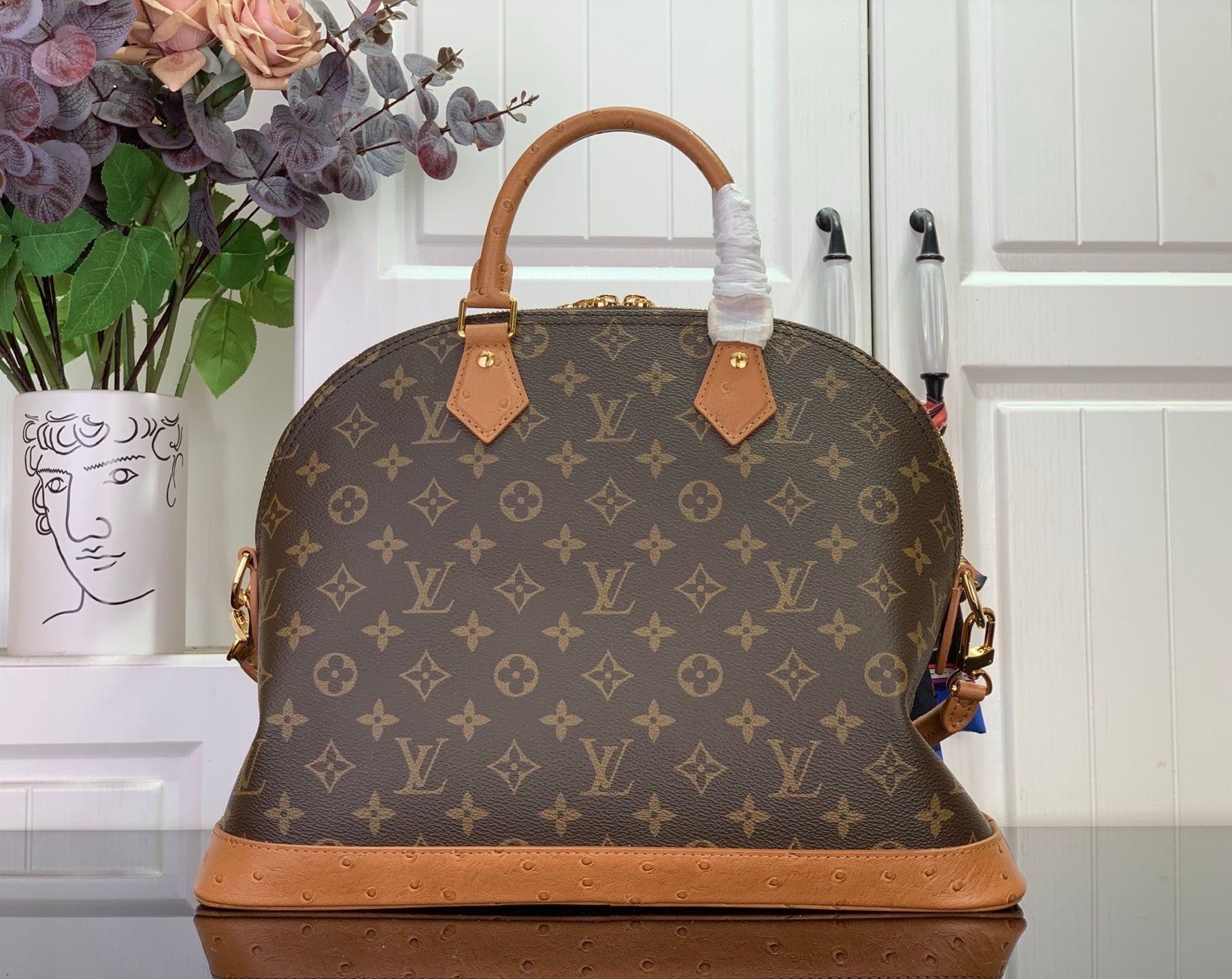 Louis Vuitton monogram duffel bag with tan top handles and brown leather tabs