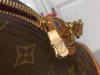 Louis Vuitton monogram crossbody bag, gold-tone zipper and clasp hardware.