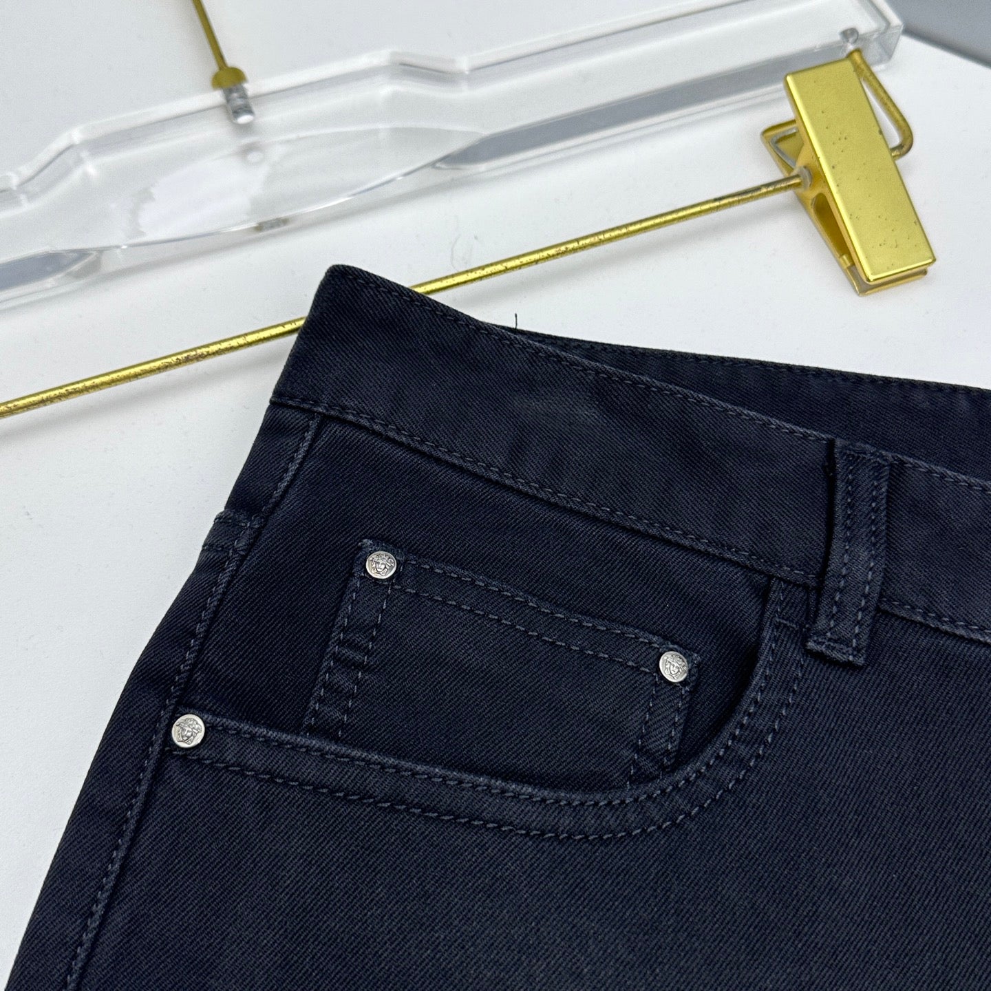 Versace dark blue jeans close-up of front pocket with metal rivets and stitching