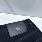 Versace dark blue jeans close-up of embossed leather logo patch on waistband