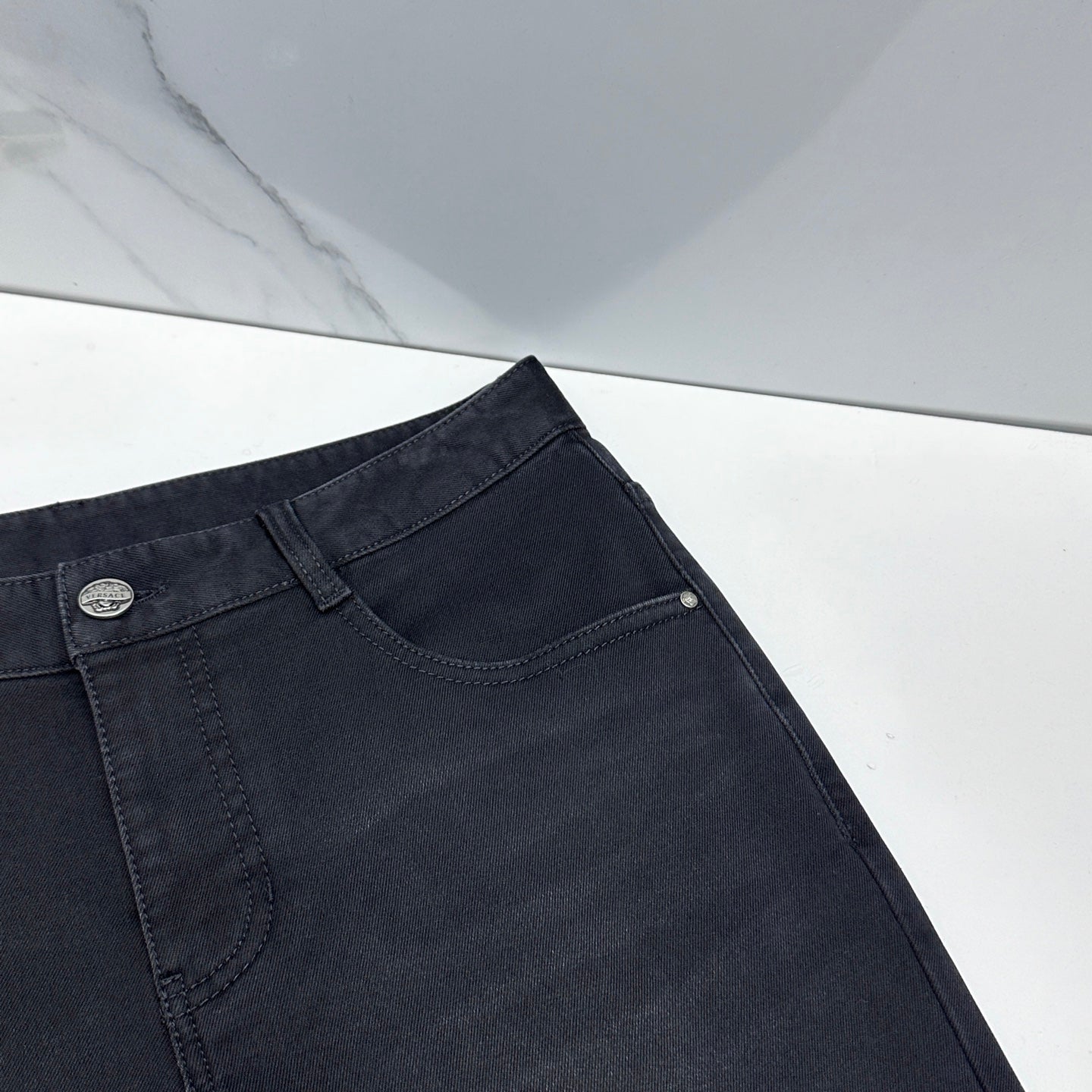 Versace dark blue denim jeans close-up of waistband with front curved pocket