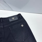 Versace dark blue denim jeans angled close-up of front pocket and logo patch