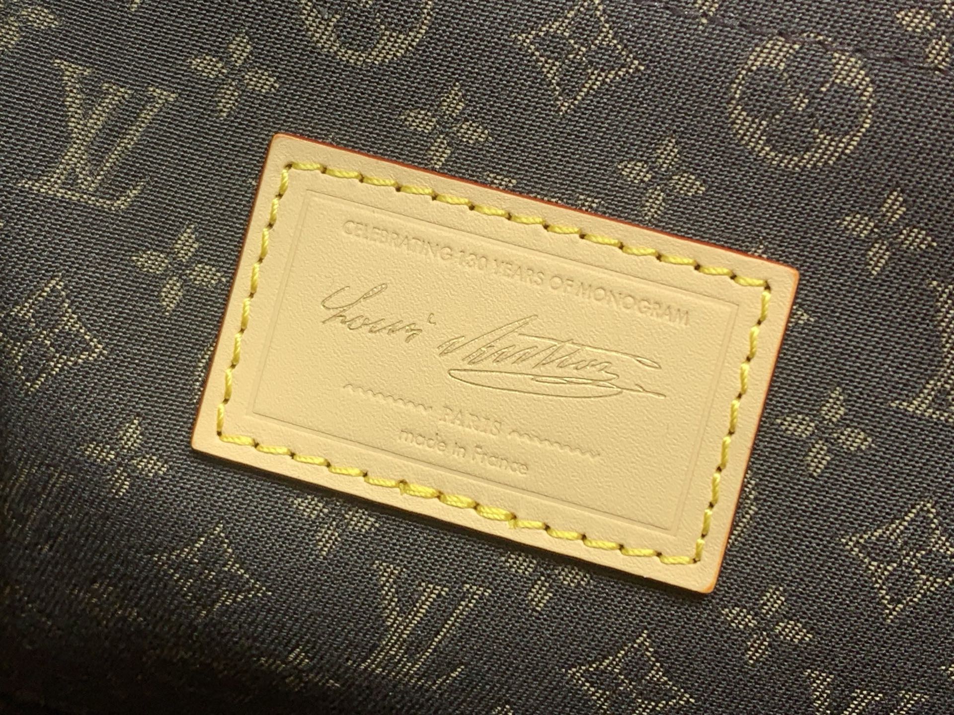 Monogram canvas label patch with gold trim and embossed text card