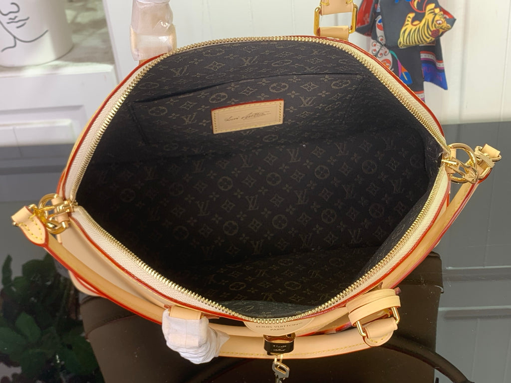 Black monogram canvas bag interior with zippered opening and small rectangular label