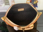 Black monogram canvas bag interior with zippered opening and small rectangular label