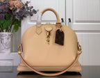 Beige dome tote bag with top handles and crossbody strap, plus hanging charm