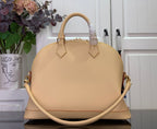 Beige dome tote bag front view with top handles and side leather straps
