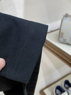 Dark navy T-shirt sleeve hem seam detail held in hand