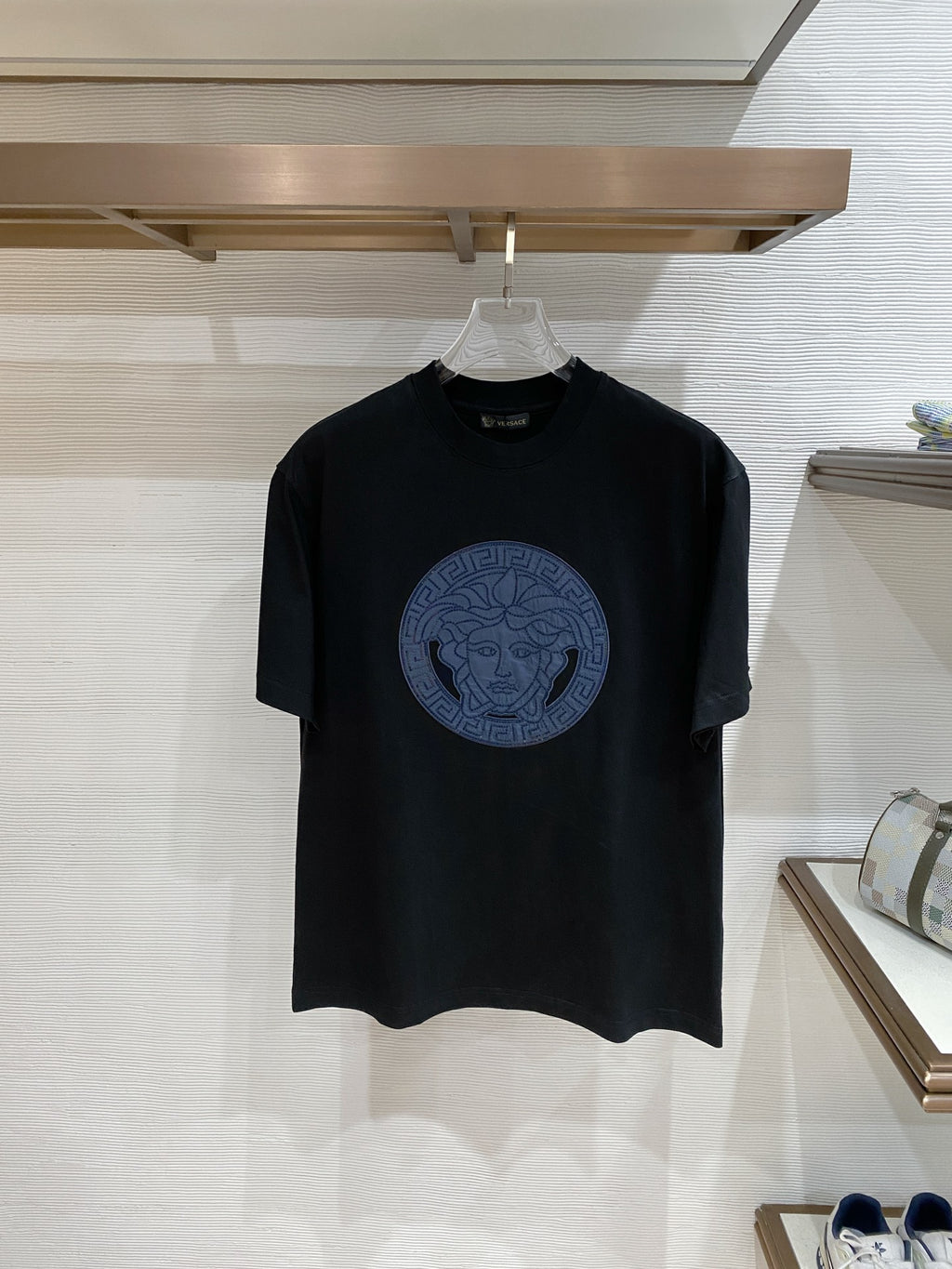 Versace black T-shirt with blue Medusa circular graphic on chest